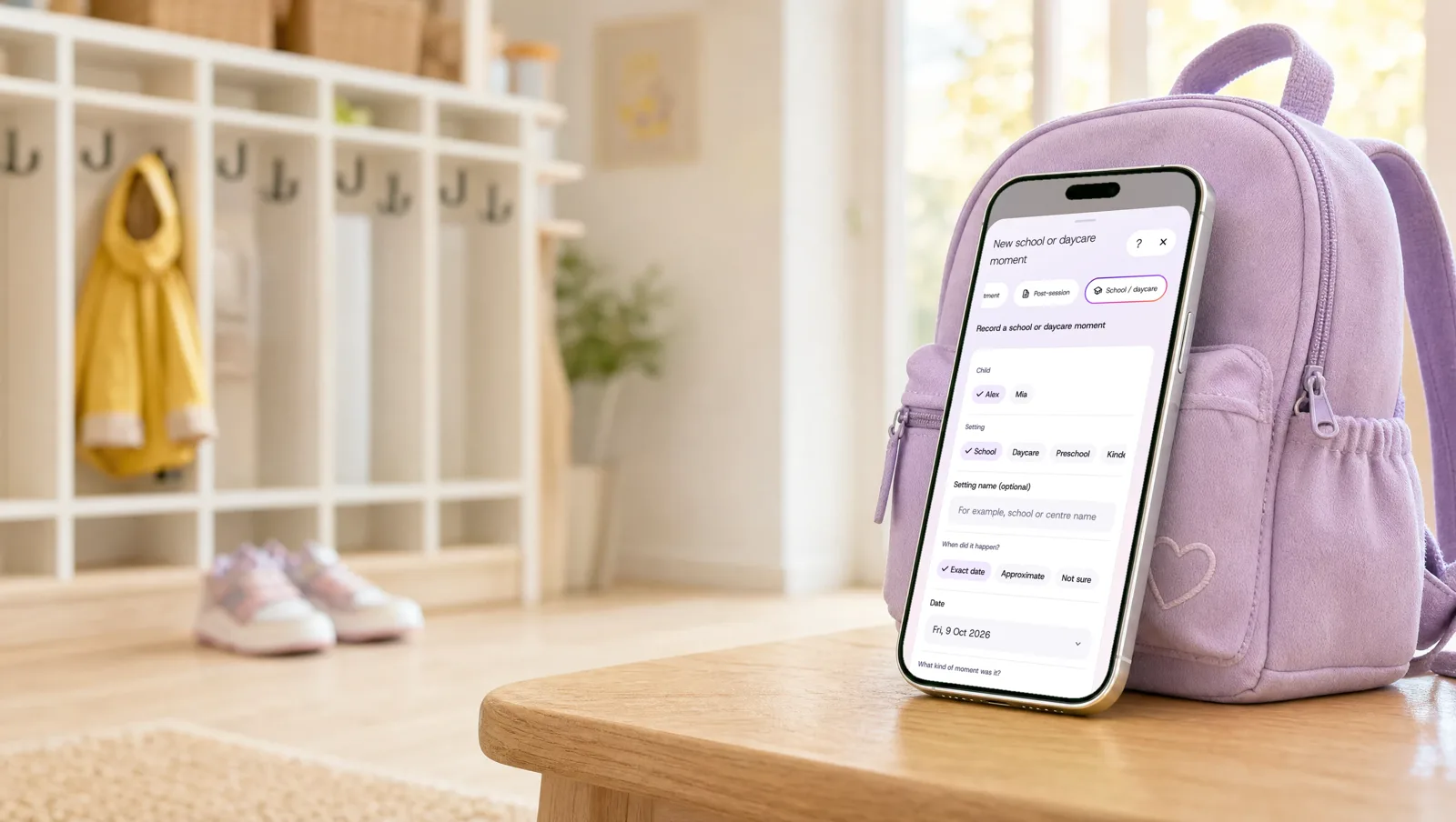 A phone leaning on a child’s backpack in a daycare entry, showing a new school or daycare moment being saved